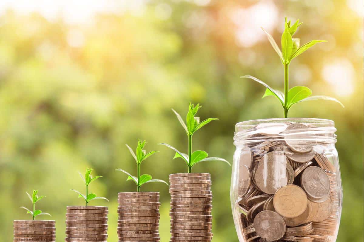 Coins in savings pots illustrating creative ways to save for travel